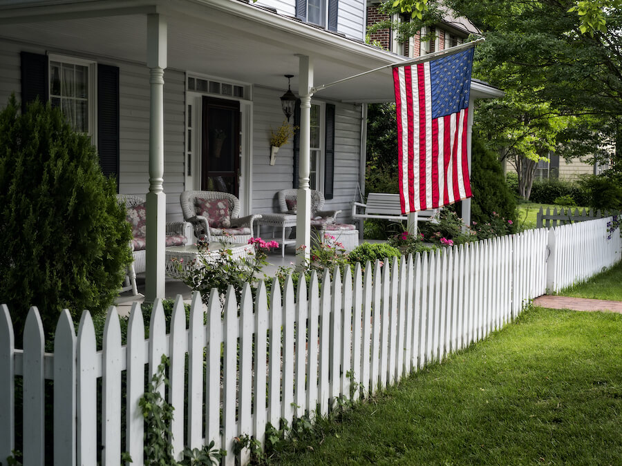 Home with american flag and white picket fence