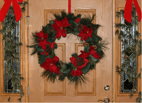 green and red wreath on wood door