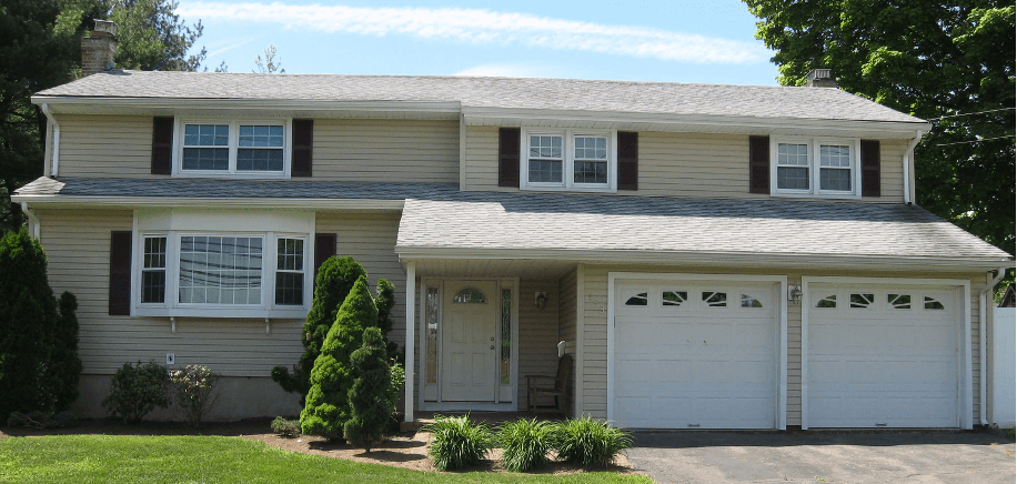 Front of tan home with white doors and windows